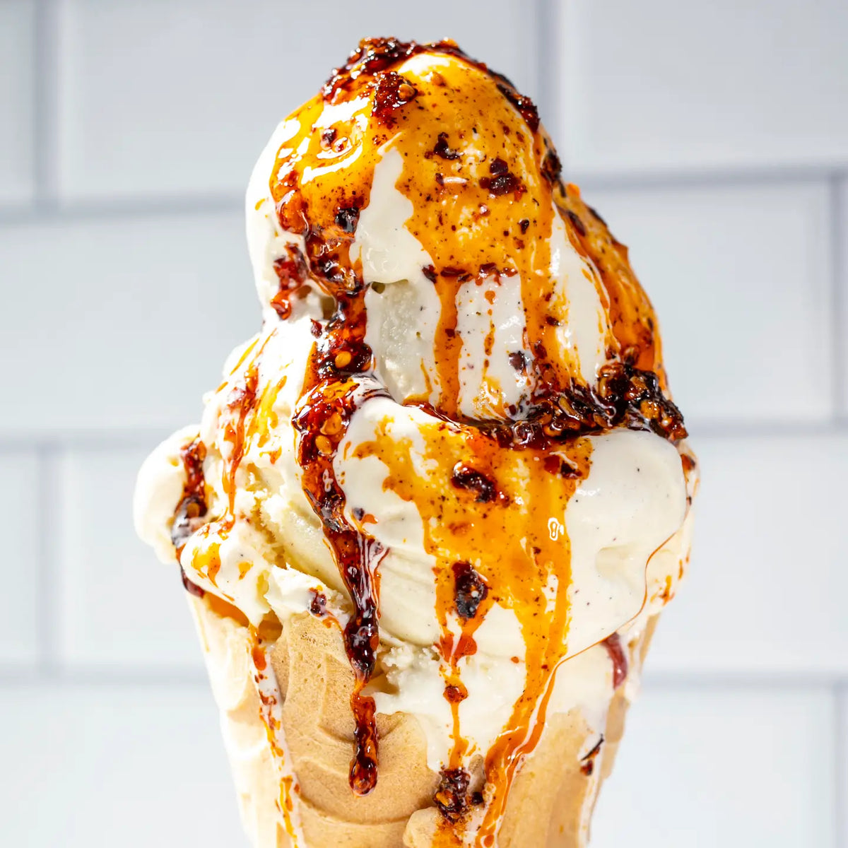 Ice cream cone drizzled with chilli oil and chilli flakes