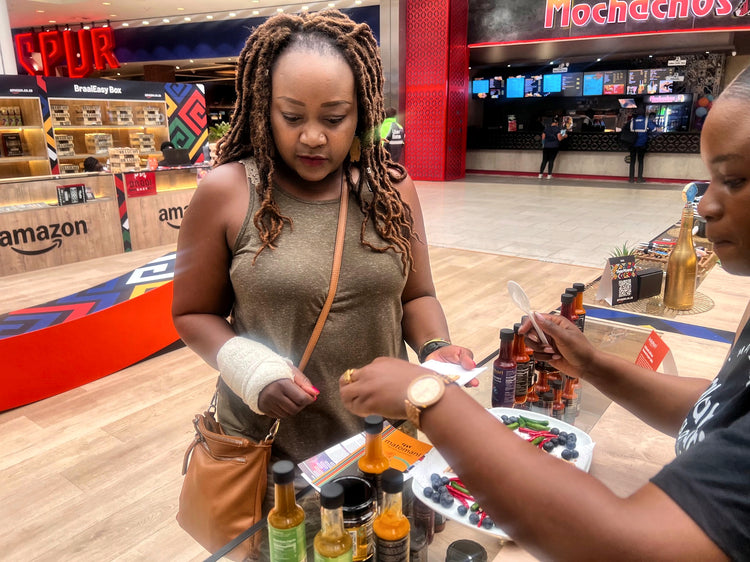 A shopper tasting Kalahari Organics hot sauces at the pop-up