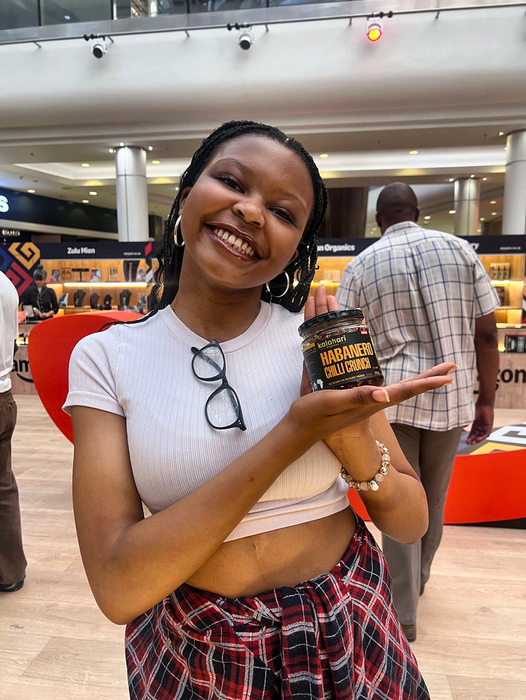A smiling customer holding a jar of Habanero Chilli Crunch