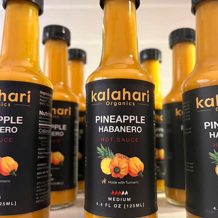 Rows of Kalahari Organics Pineapple Habanero hot sauce bottles