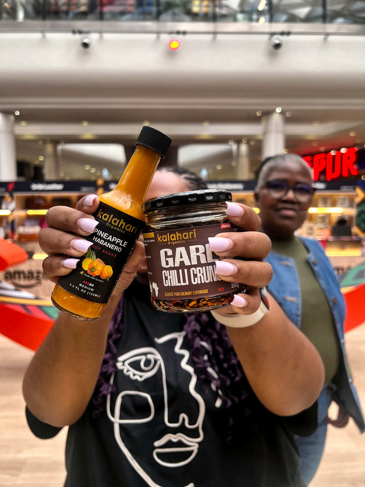 A customer holding Pineapple Habanero hot sauce and Garlic Chilli Crunch